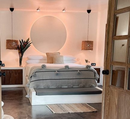 A wooden door leading into a boutique bedroom with a bed at beautiful boutique hotel Vayu Retreat Villas in Costa Rica