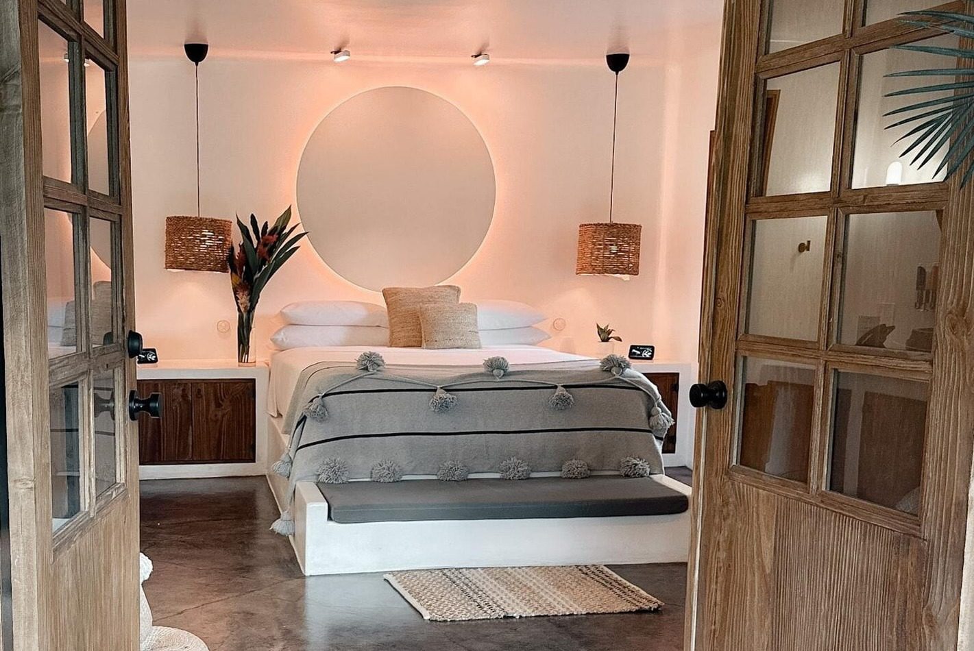A wooden door leading into a boutique bedroom with a bed at beautiful boutique hotel Vayu Retreat Villas in Costa Rica