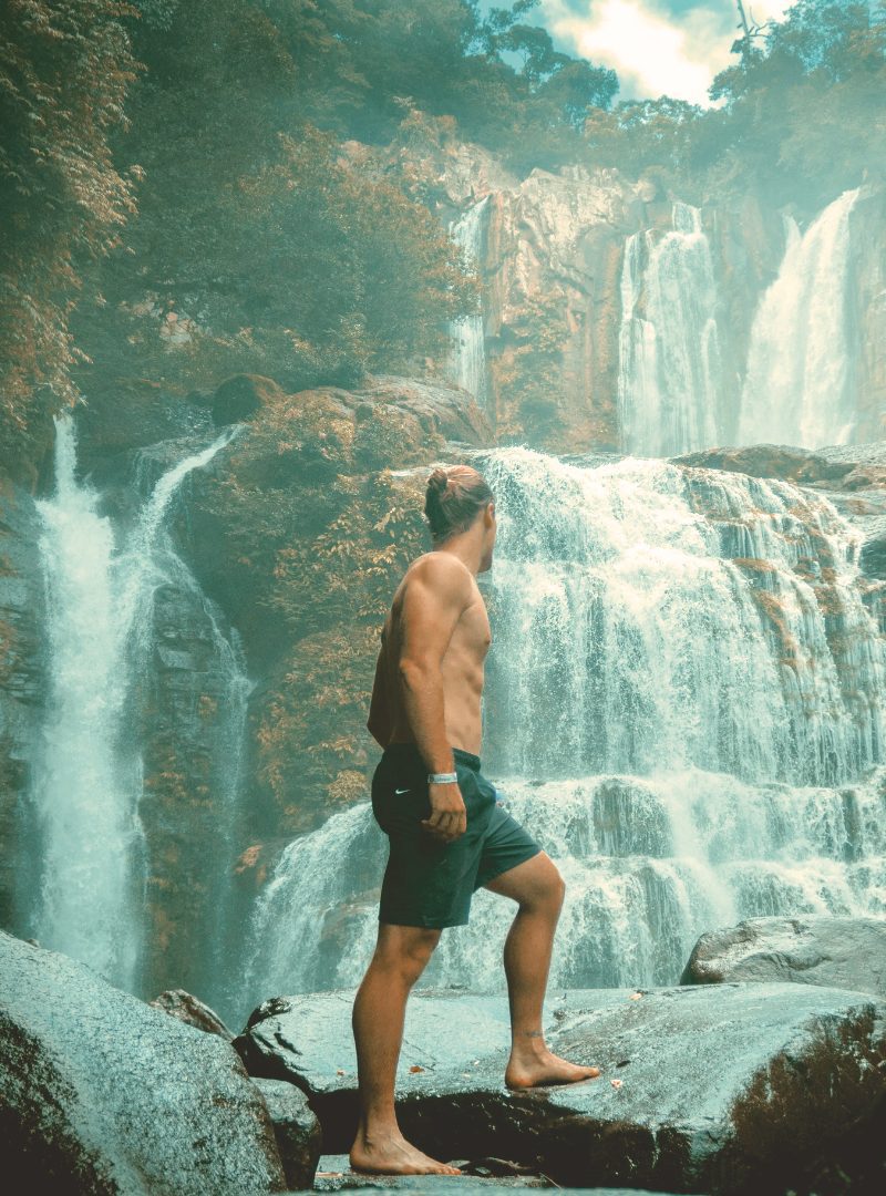 At Vayu Retreat Villas, ensconced within the heart of the Costa Rican rainforest, a transformative escape unfolds. In this captivating snapshot, a man stands before a majestic waterfall, his gaze transfixed by its cascading beauty. The innate connection between the Costa Rican landscape and Vayu Retreat's ethos of holistic well-being becomes palpable as he witnesses nature's splendor. This boutique hotel, synonymous with luxury, offers more than an escape—it's a journey toward revitalization. Amidst the lush foliage, the very air seems to vibrate with the energies of this Wellness Retreat, where the symphony of the rainforest harmonizes with the soul-nourishing practices embraced within. As he stands there, he's not merely observing; he's absorbing the essence of a vacation that seamlessly blends opulence with the authenticity of the rainforest, a tranquil haven for both body and spirit.