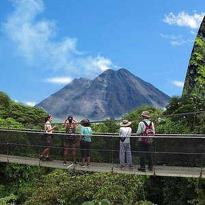 people watching a volcano over the hanging bridge