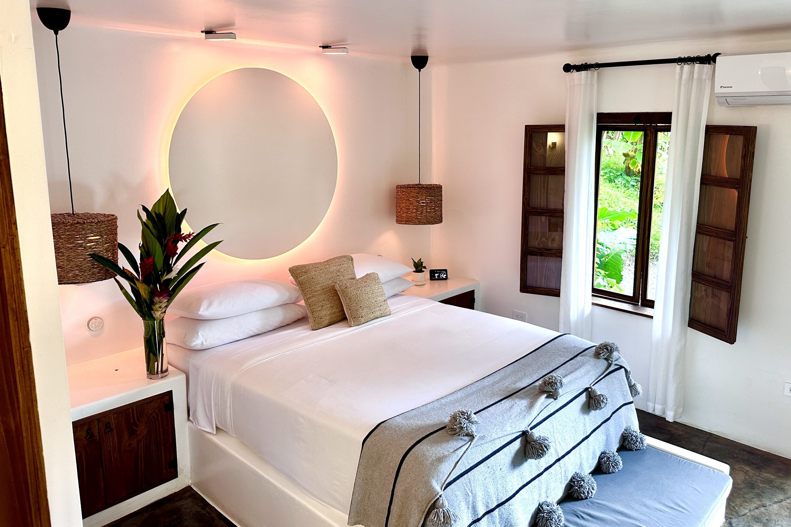 Immerse yourself in the epitome of modern luxury at Vayu Retreat Villas, nestled within the heart of the lush Costa Rican rainforest in the charming town of Uvita. Stepping into your boutique hotel room, you're immediately drawn to the centerpiece of comfort and relaxation – the inviting bed. Adorned with plush linens and an array of pillows, it's a sanctuary of rest amidst the vibrant tropical surroundings. The contemporary decor seamlessly melds with the rainforest's natural beauty, creating a holistic haven where every detail speaks of mindful design. As part of the all-inclusive Costa Rica experience, this vegetarian resort harmonizes indulgence with well-being, offering a perfect escape for those seeking both luxury and holistic rejuvenation. Your stay at Vayu Retreat Villas is more than a vacation; it's a holistic wellness retreat that embraces the essence of the rainforest and the tranquility of a boutique sanctuary, promising an unforgettable fusion of comfort, elegance, and rejuvenation.