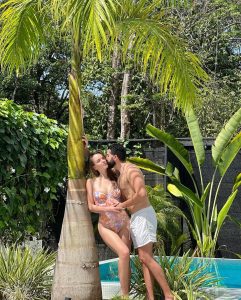 A couple enjoying a romantic moment by the pool at Vayu Retreat Villas, the ultimate all-inclusive honeymoon boutique hotel in Costa Rica, surrounded by lush tropical greenery.