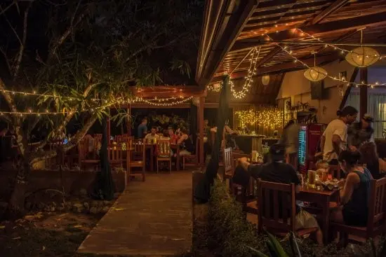 Nighttime dining at Carlitos Restaurant, one of the best restaurants in Uvita, Costa Rica, with outdoor seating and string lights. A short drive from Vayu Retreat Villas 