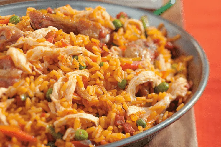 A hearty plate of arroz con pollo, featuring shredded chicken, mixed vegetables, and flavorful rice, commonly served at a soda restaurant Costa Rica, offering a taste of local cuisine to visitors of the best boutique hotel Costa Rica