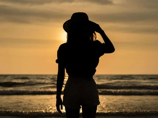 Silhouette of a female solo traveler enjoying a sunset on a beach in Costa Rica. Perfect destination for solo travel and wellness retreats