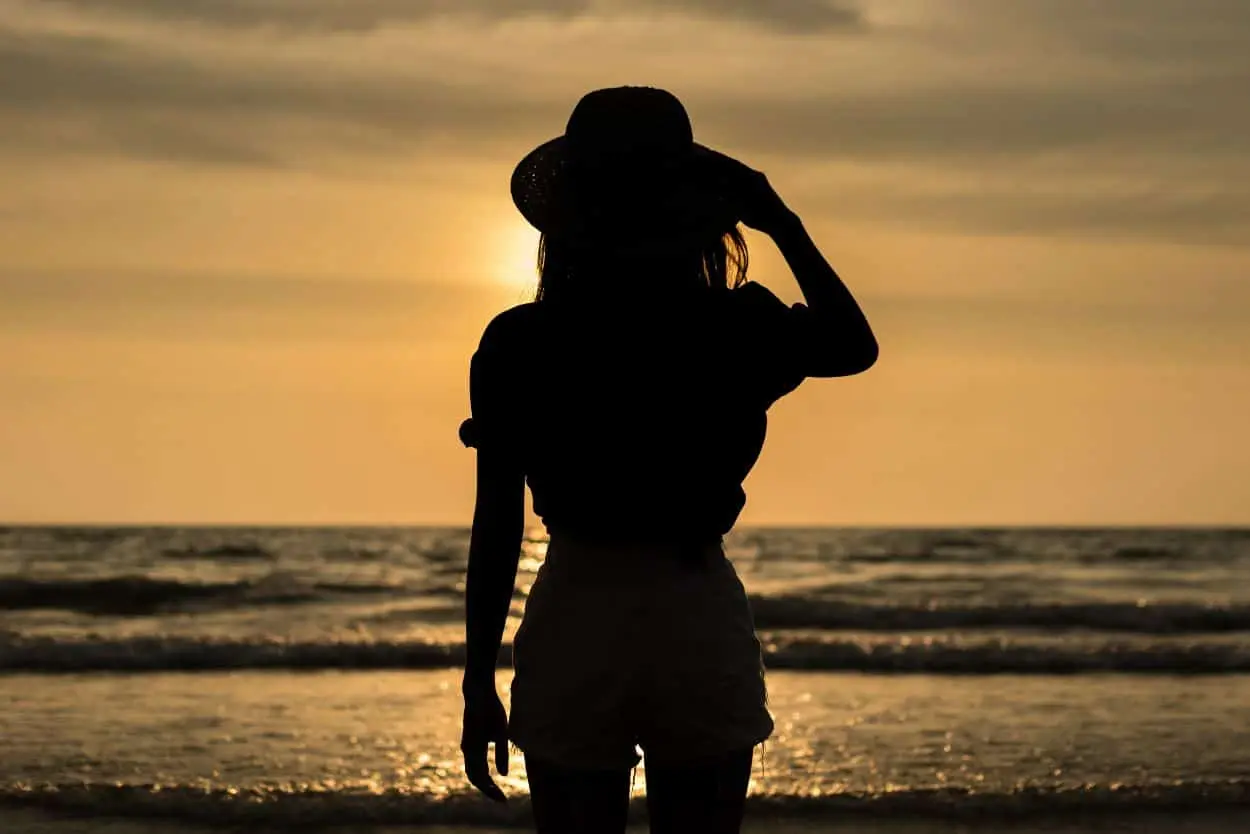 Silhouette of a female solo traveler enjoying a sunset on a beach in Costa Rica. Perfect destination for solo travel and wellness retreats