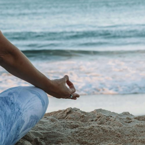 Close-up of a person meditating on the beach, showcasing mindfulness practices at Vayu Retreat Villa in Costa Rica.