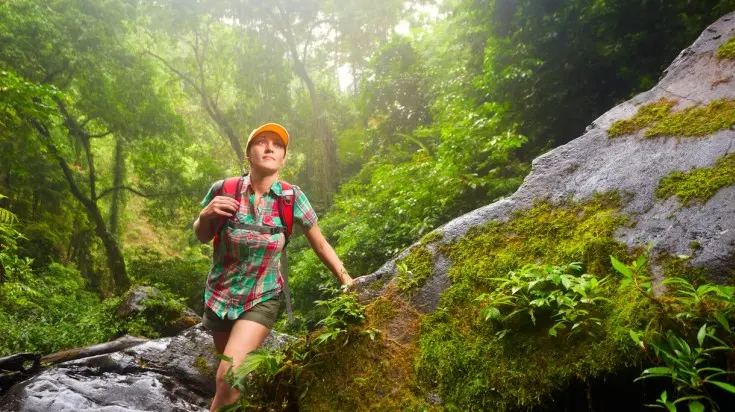A woman hiking through the lush rainforest of Corcovado National Park, showcasing the pristine wilderness near Vayu Retreat Villas, a premier boutique hotel in Uvita.
