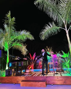 A magical evening performance with Rafael Steyners at Vayu Retreat Villas during Christmas in Costa Rica, with vibrant lights and tropical palm trees.